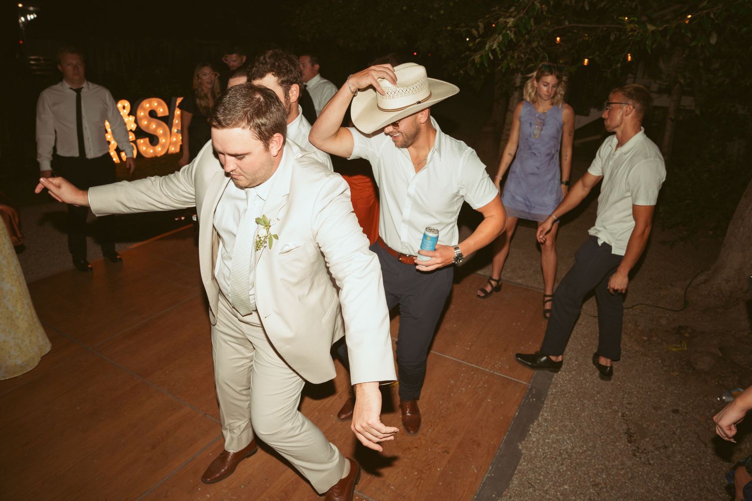Guests enjoying themselves on the dance floor at a nighttime outdoor celebration.