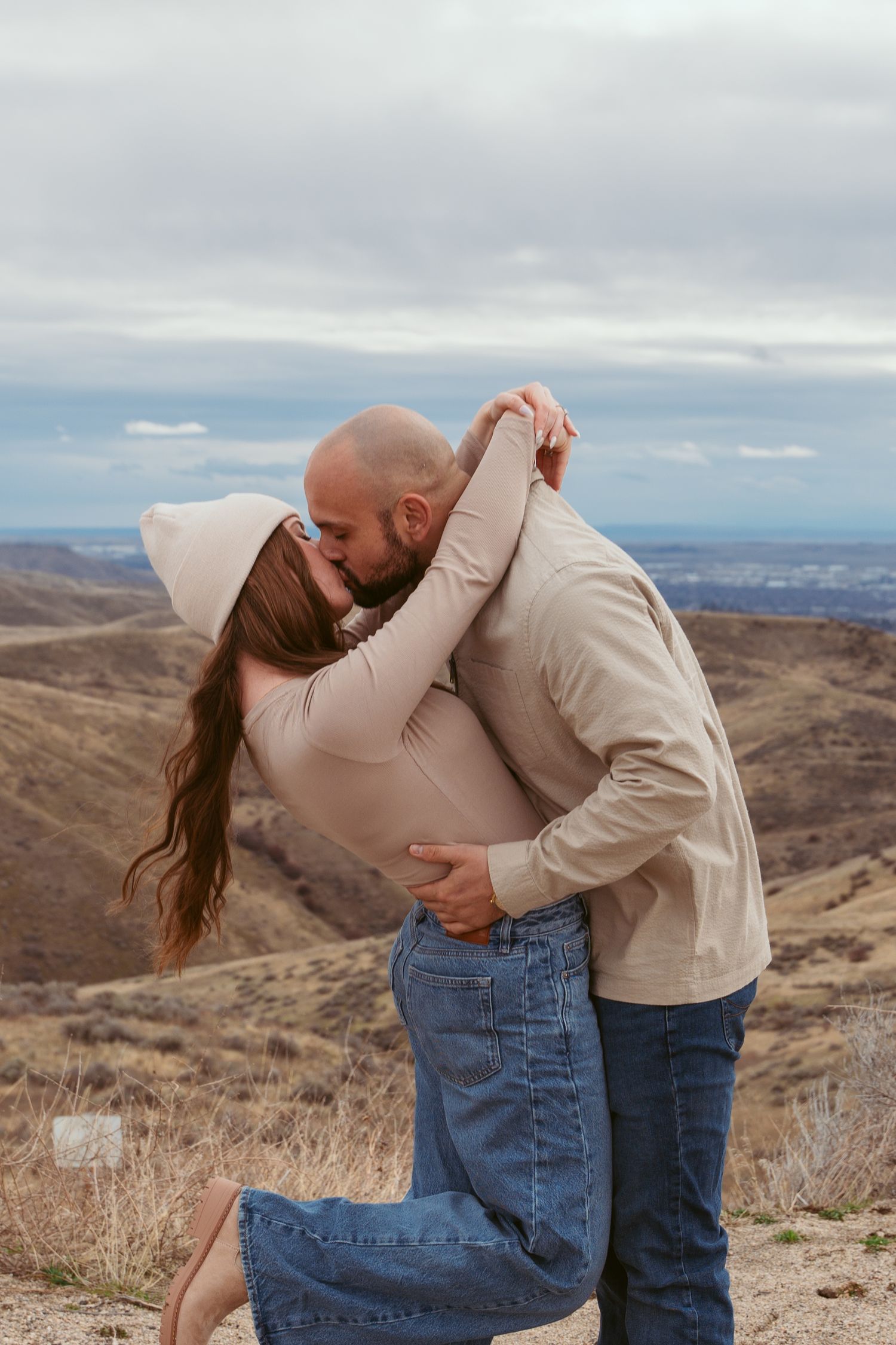 A romantic couple embraces against a scenic mountain backdrop in a series of affectionate poses.
