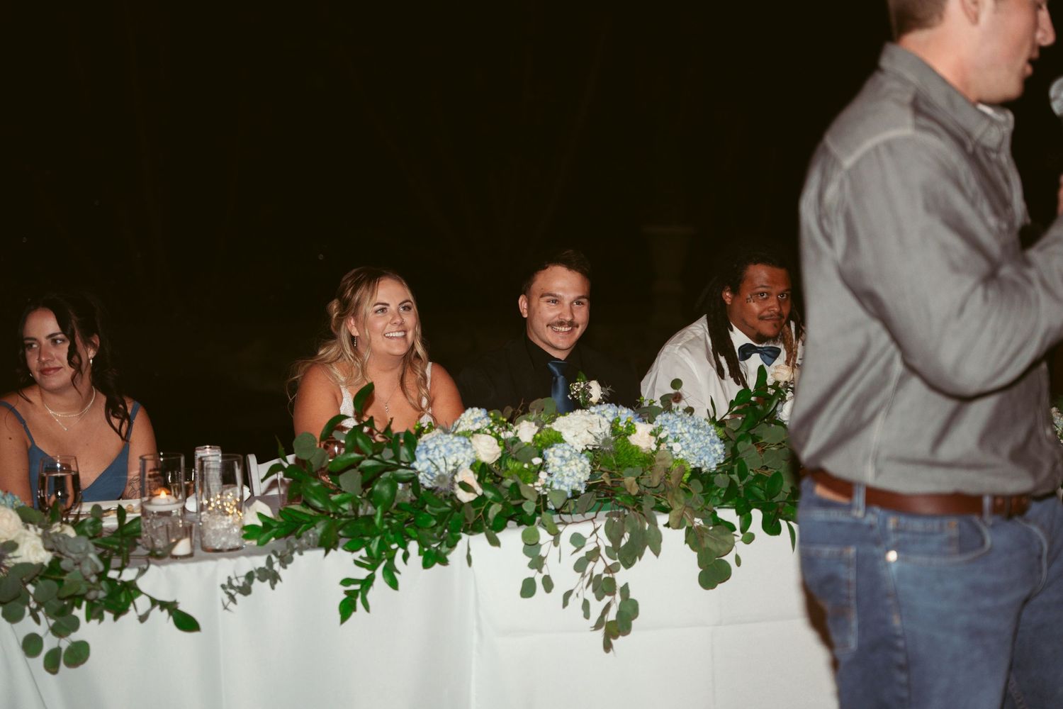 Wedding reception guests mingling and dancing under decorative lighting.