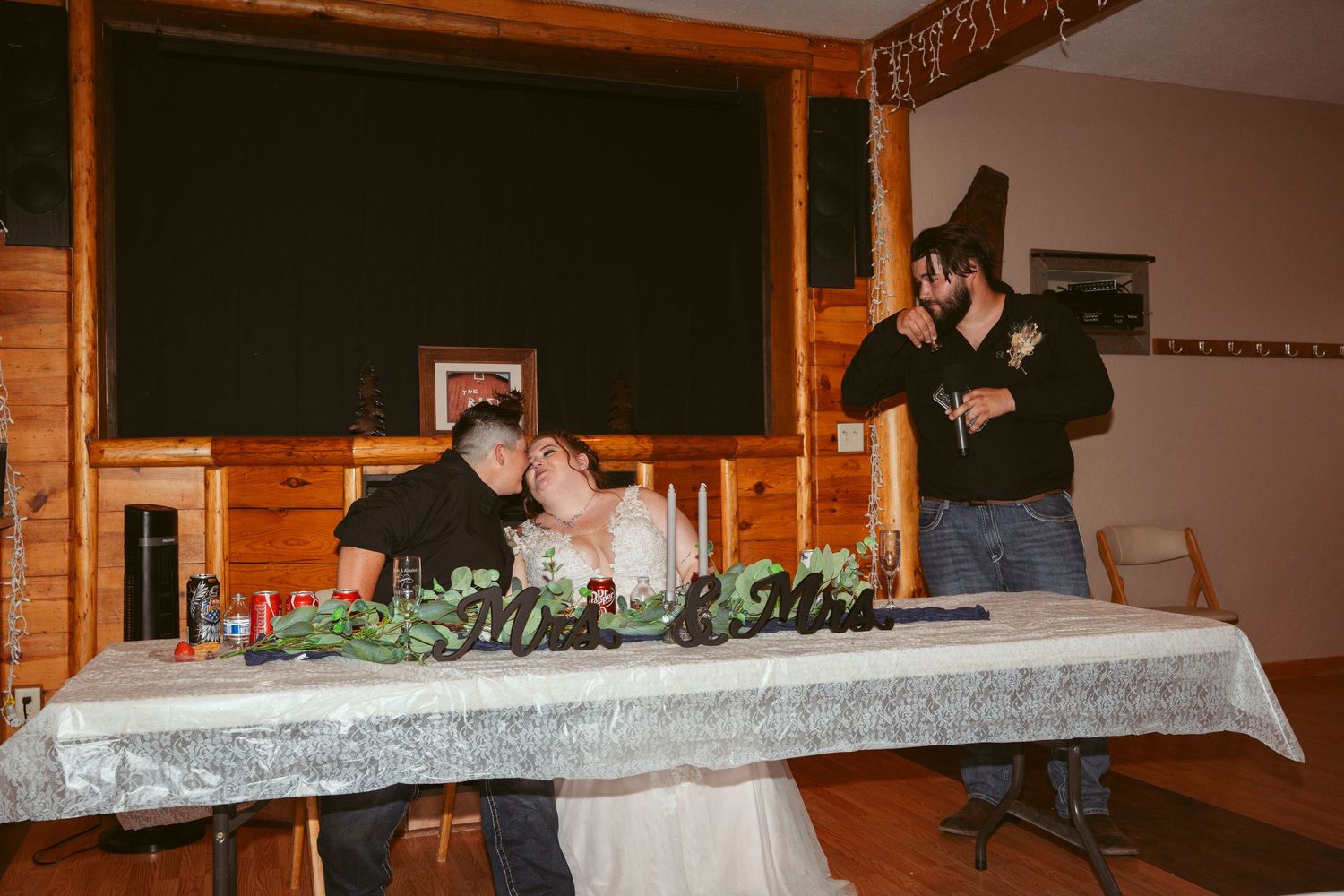 Rustic wooden venue interior with decorative table settings and greenery garlands.