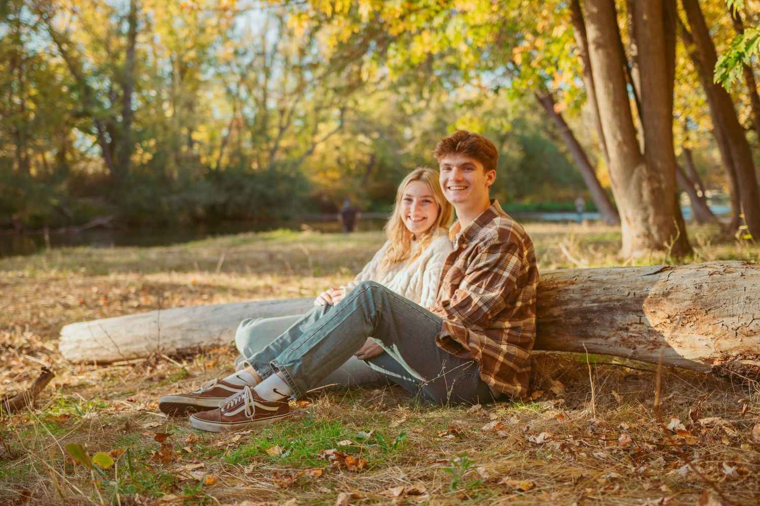 Romantic outdoor photoshoot in wooded area with golden autumn lighting.