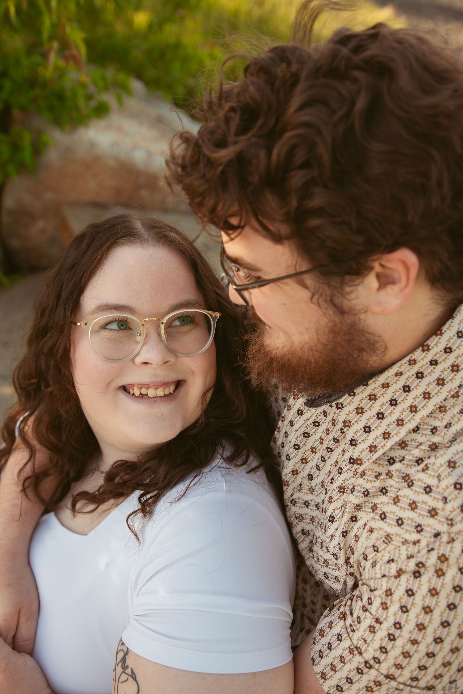 Close-up portrait of couple sharing tender moments outdoors with natural lighting.