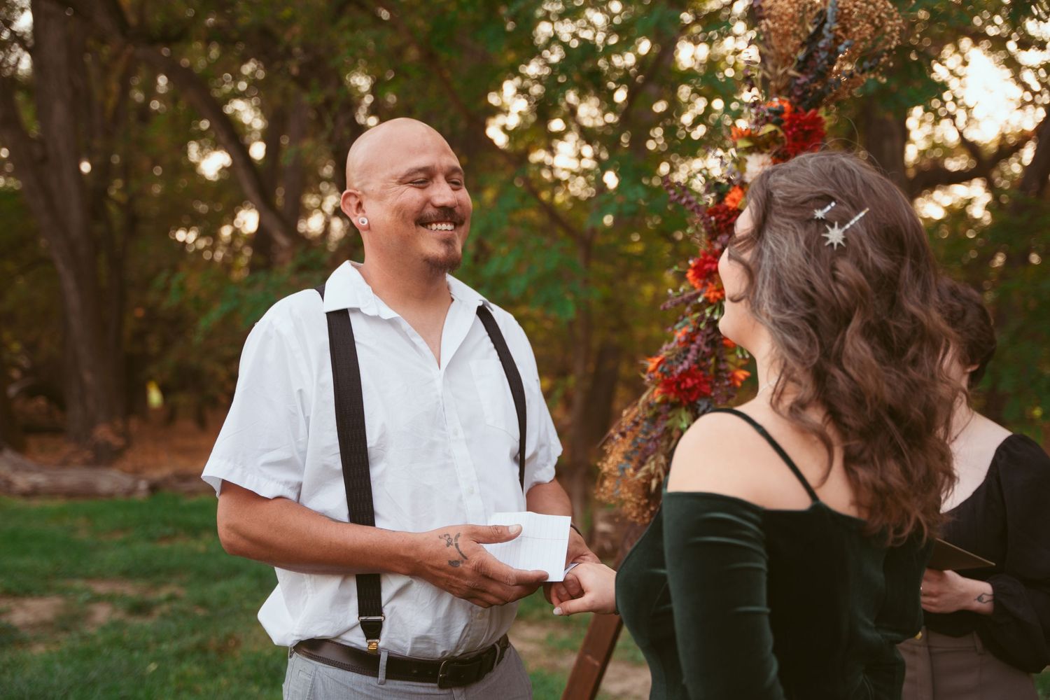 A couple shares a joyful moment during their outdoor wedding vows.