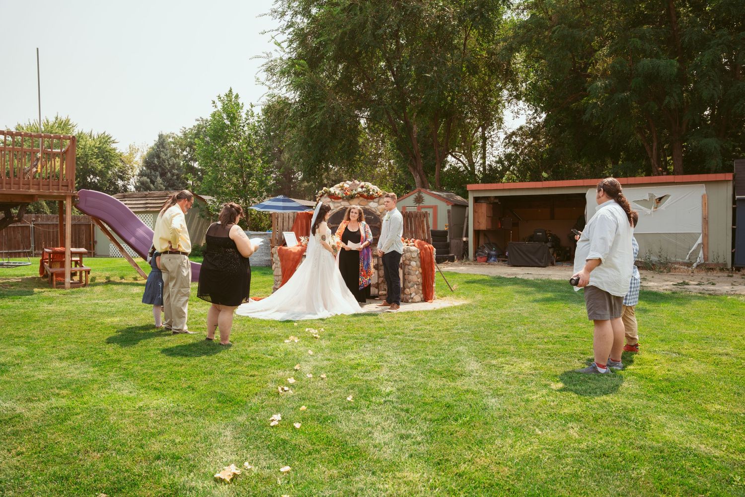 Wide angle view of an outdoor wedding ceremony setup on a green lawn.