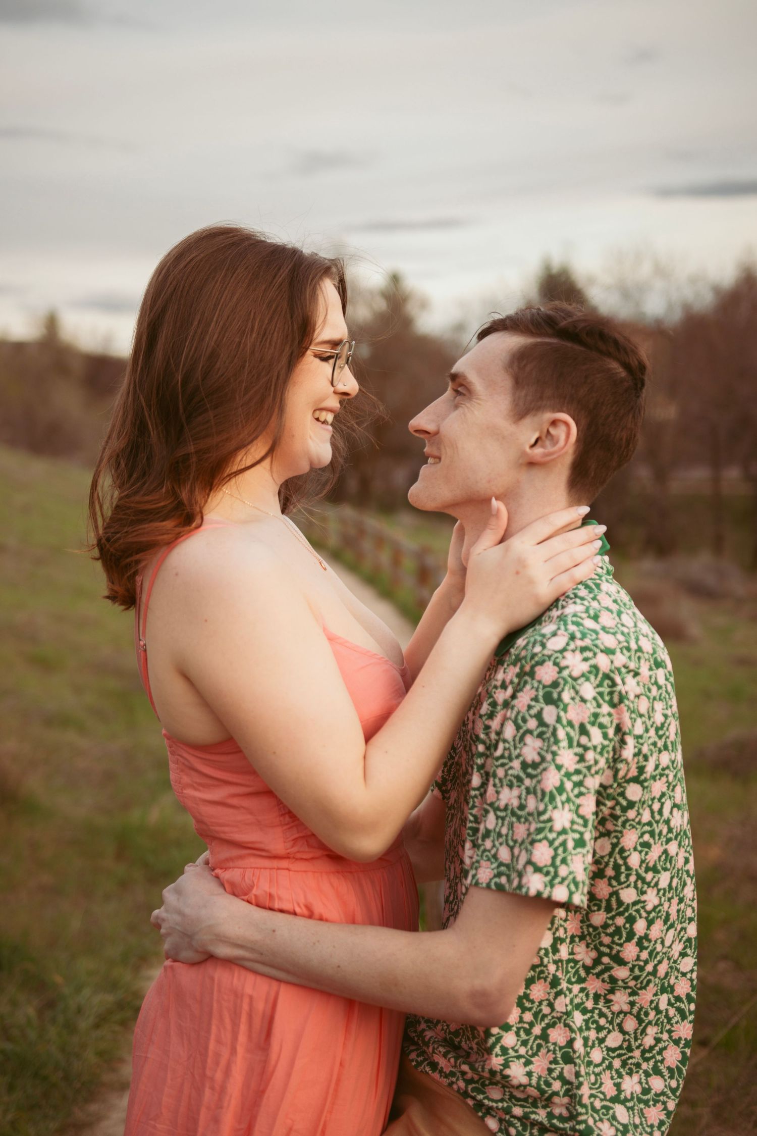 A romantic couple shares a close moment outdoors in spring attire.