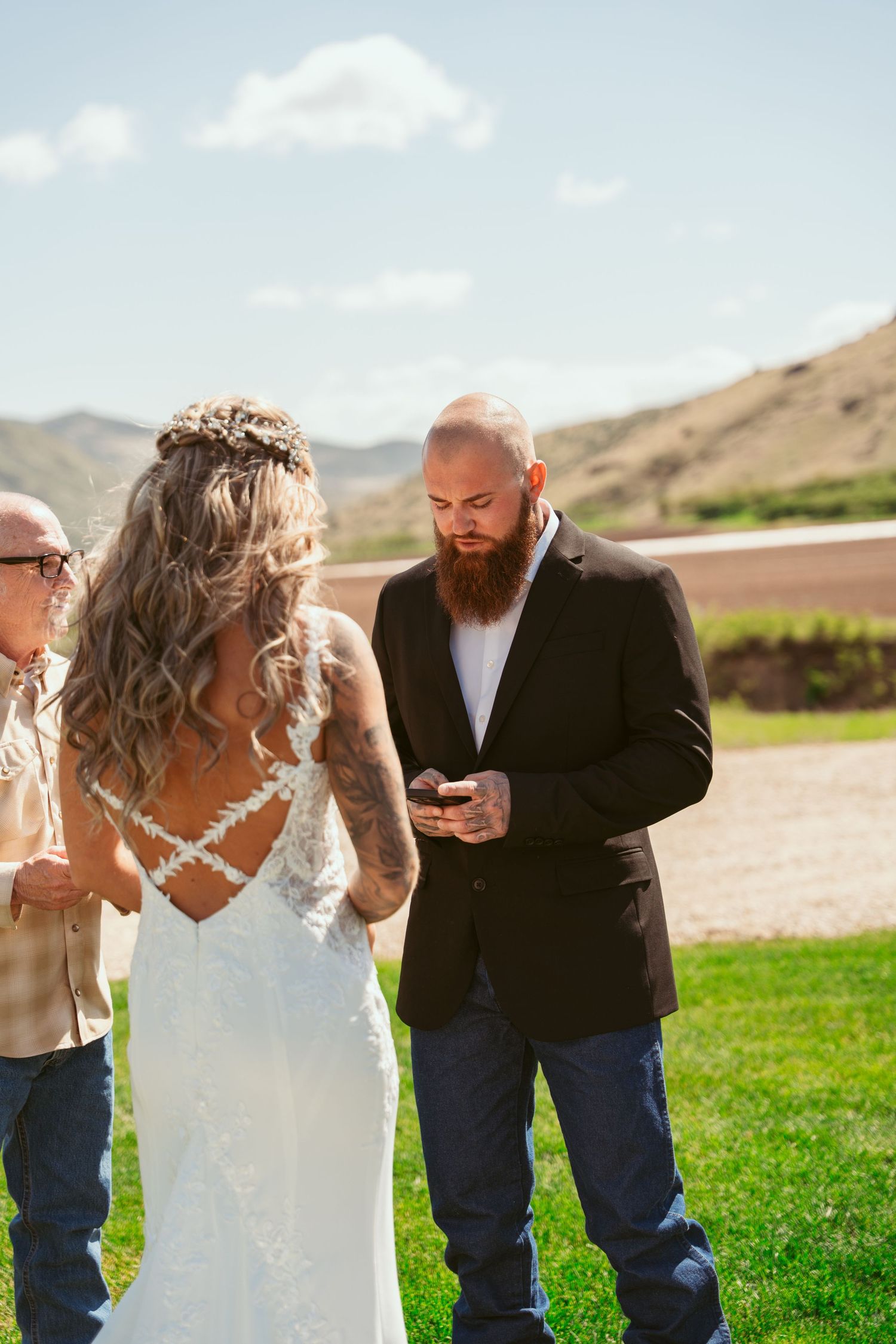 Couple exchanging vows during an intimate outdoor wedding ceremony with mountain views.