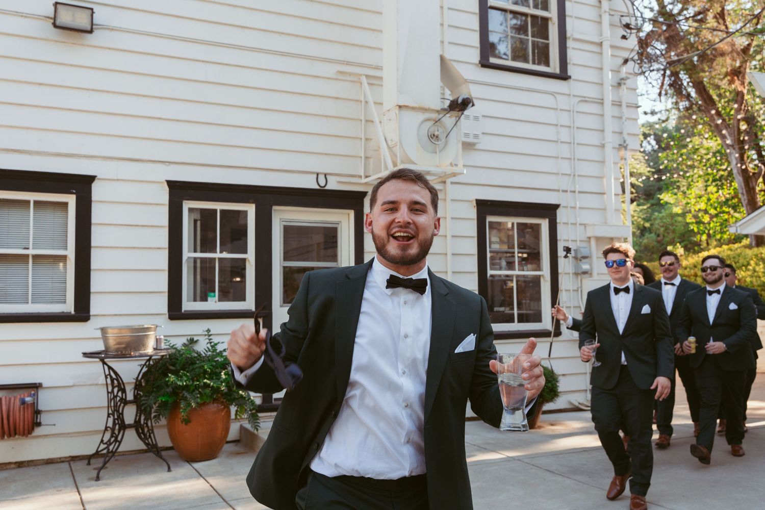 A joyful celebration outside a white house with formal attire and festive atmosphere.