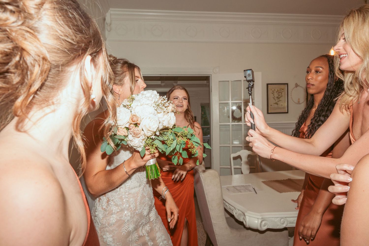 Joyful celebration moments during an indoor wedding reception with vintage-style lighting.