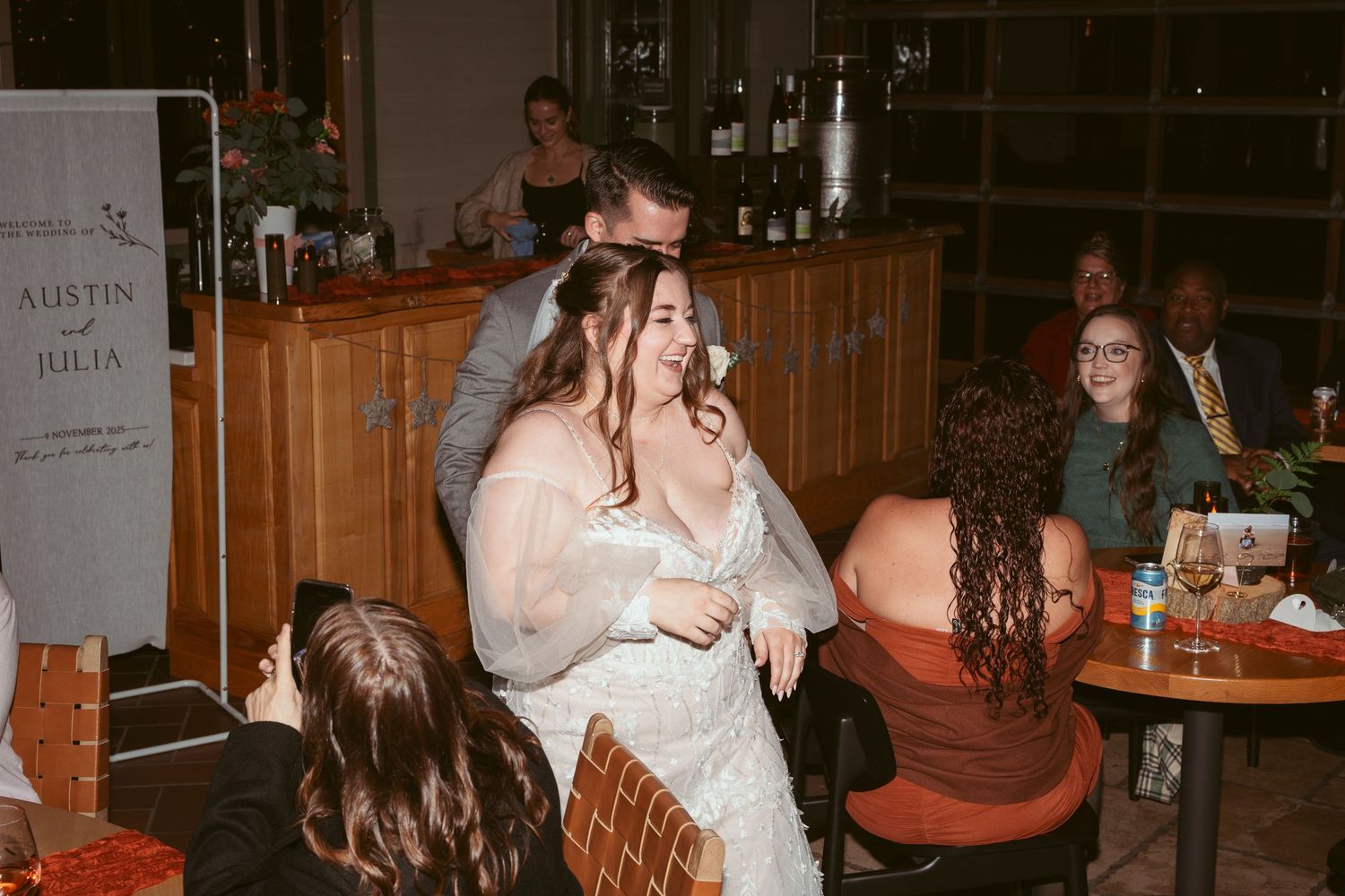 Wedding reception scene in a rustic wooden venue with warm lighting.