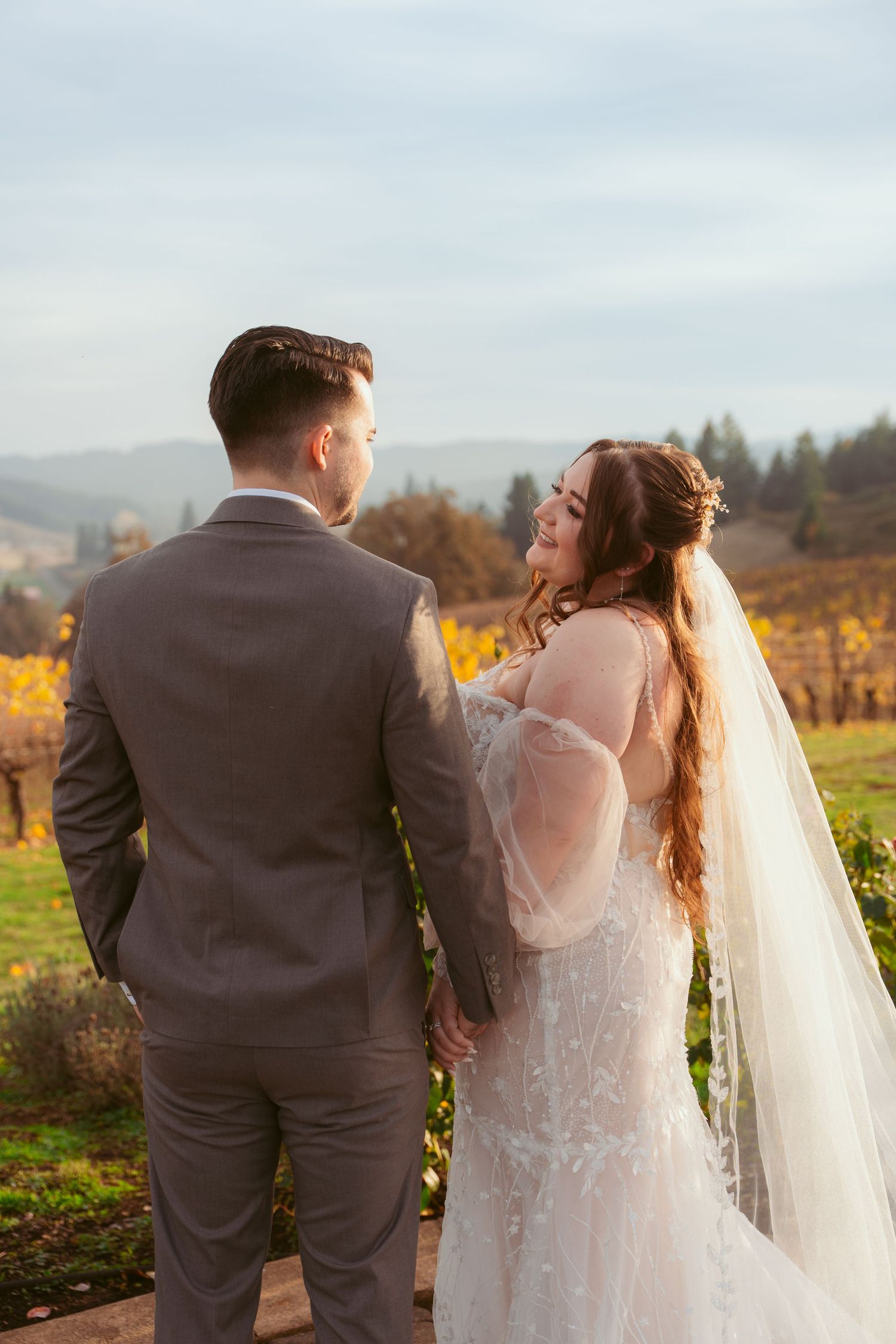 Couple shares romantic moment in vineyard during golden hour wedding photography session.