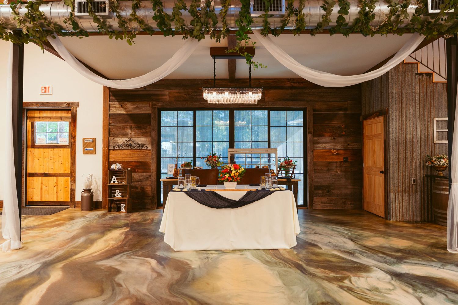 Panoramic view of an elegant wedding venue with white draping and wooden accents.
