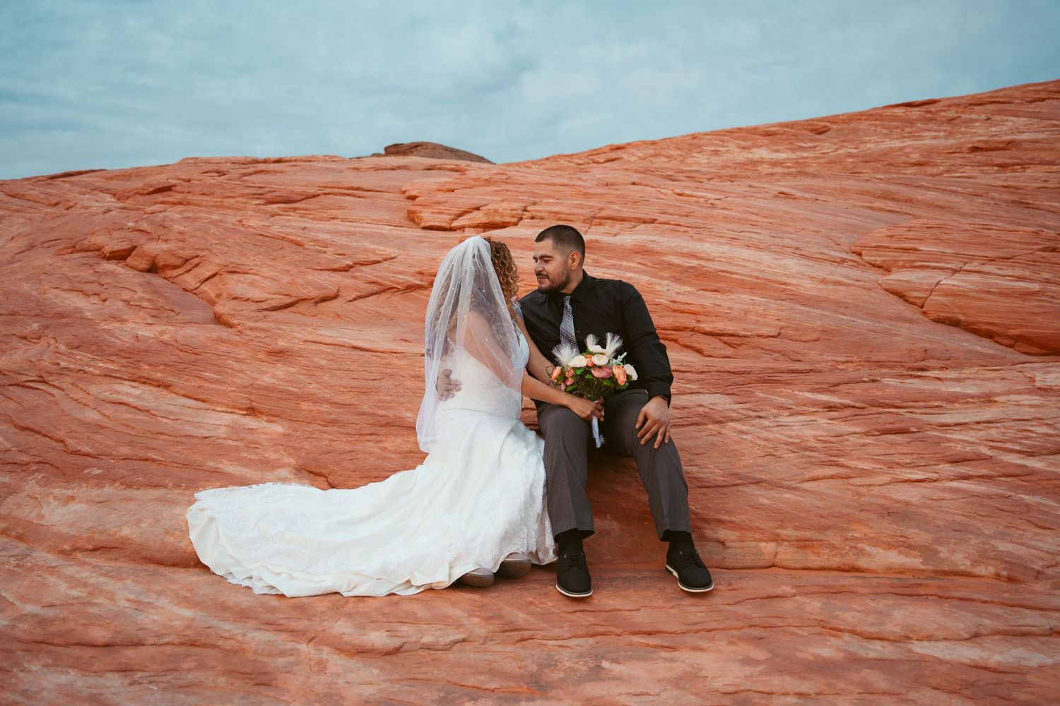 Romantic wedding portraits captured on dramatic desert sandstone formations.