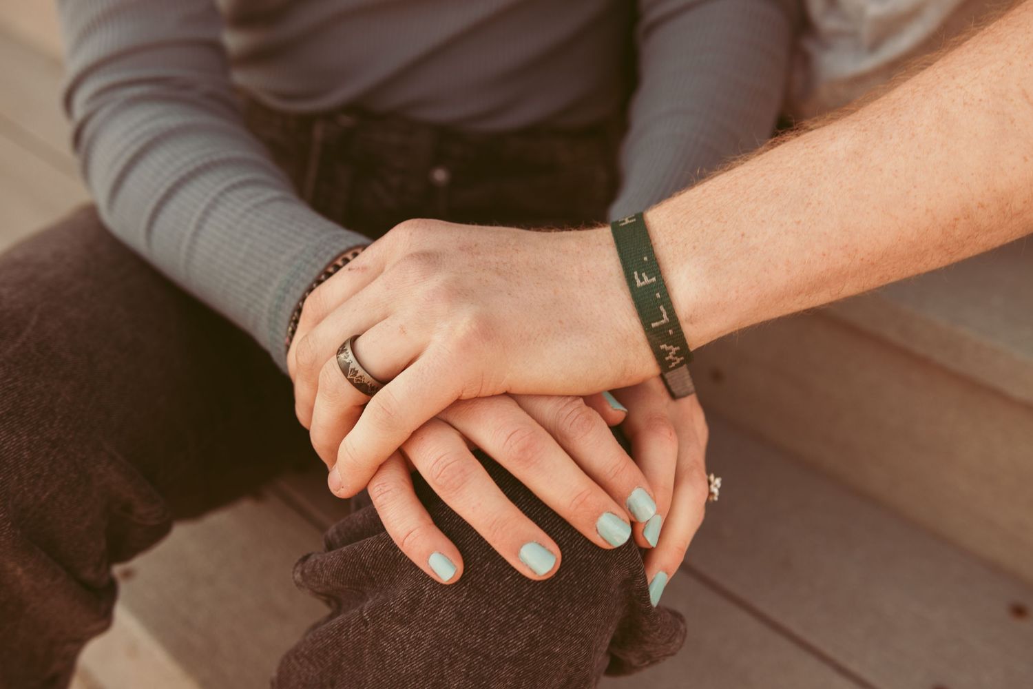 Close-up shot of hands with rings showing affection and connection.