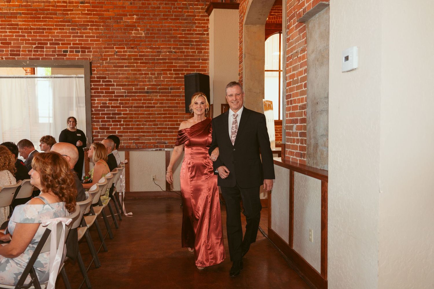 Wedding celebration in a bright industrial space with exposed brick walls and high ceilings.