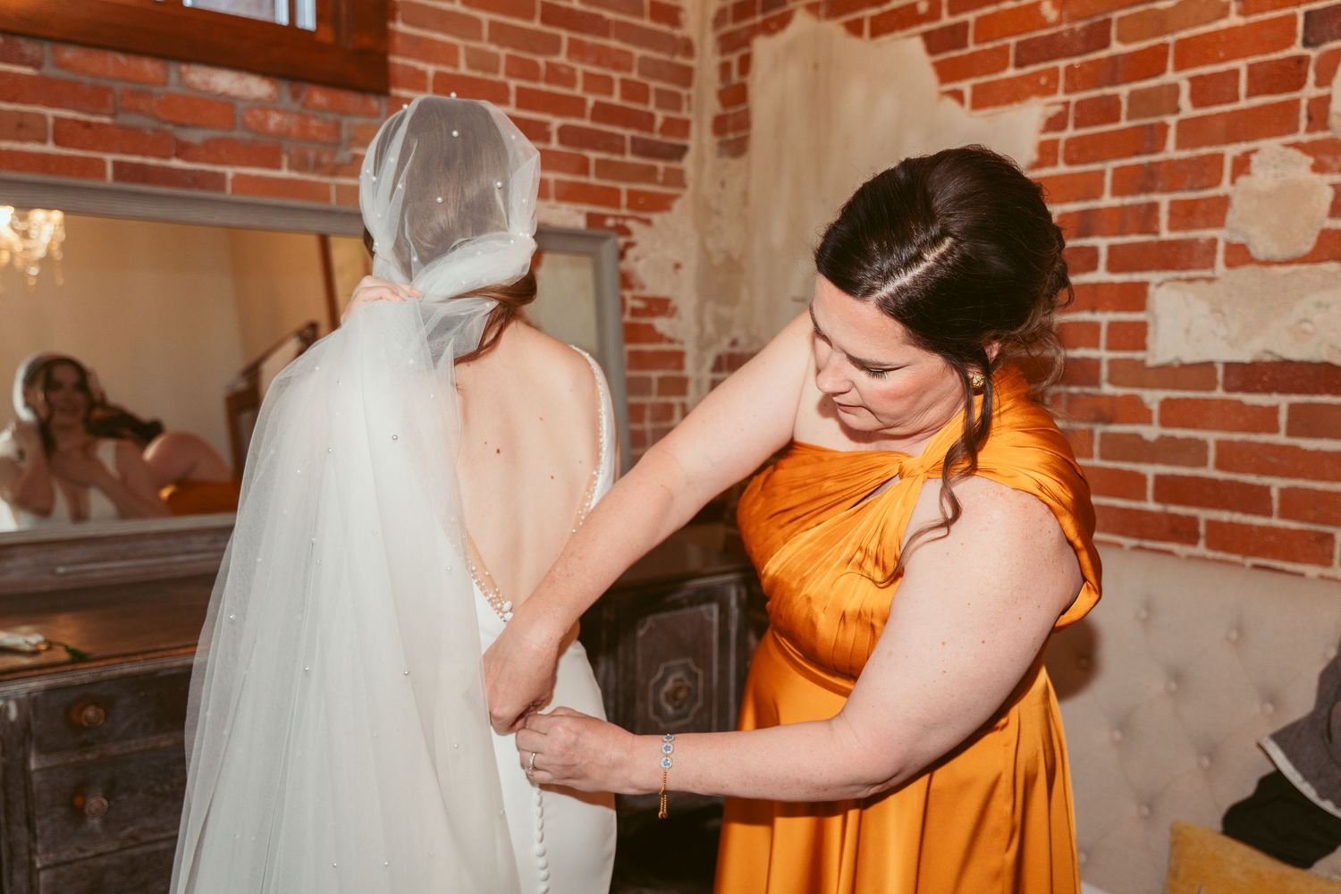 Bridesmaids in pastel dresses helping with wedding preparations.