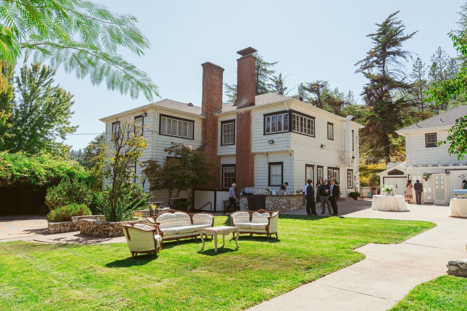 Exterior view of residential homes and buildings with green lawns and walkways.