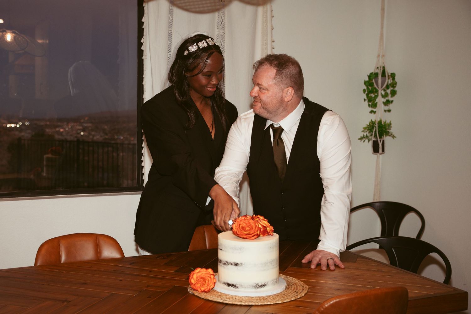 Wedding cake and decorations displayed on wooden tables at an indoor reception.