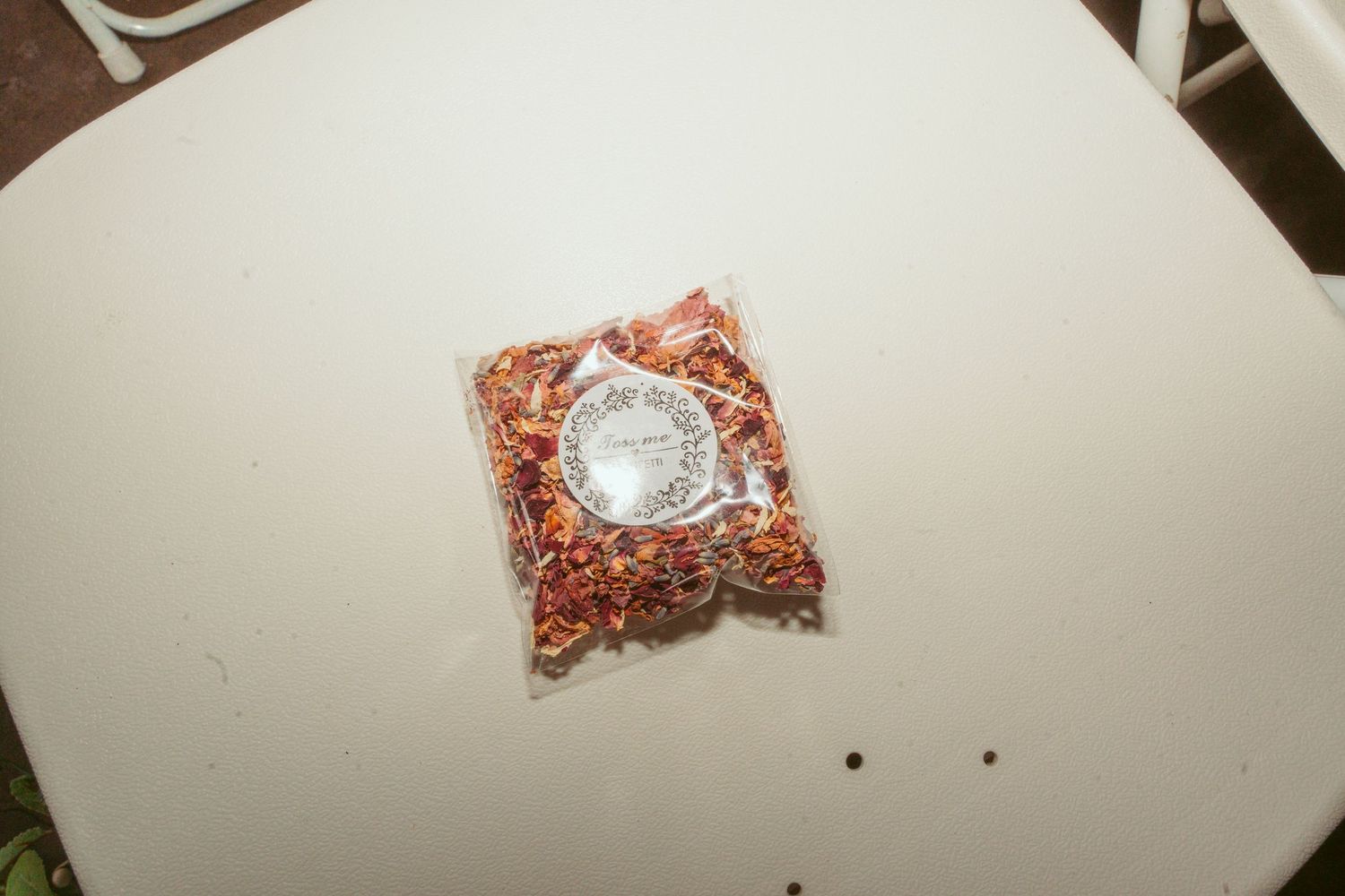 A small bag of confetti or decorative material on a white surface.
