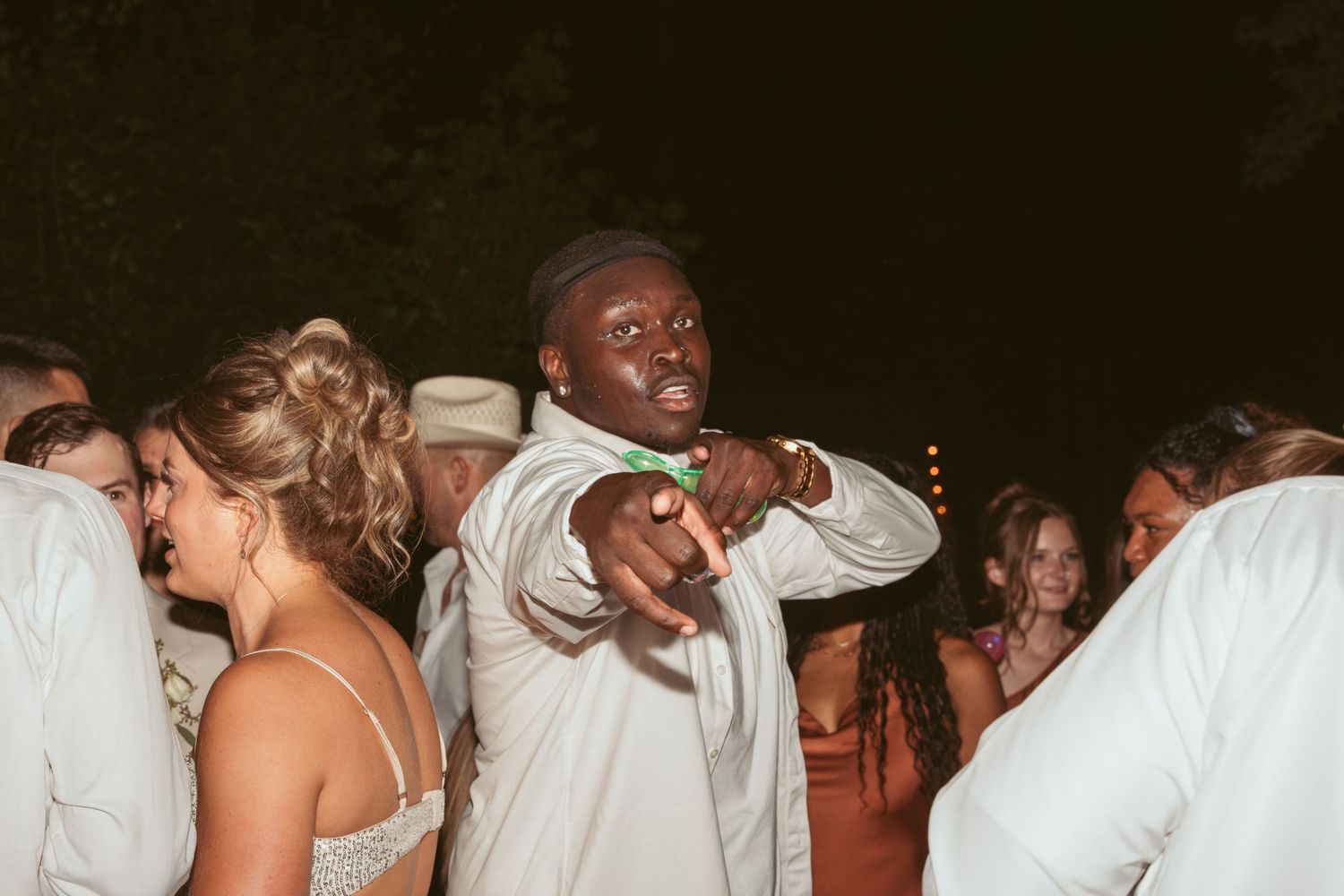Party guests dancing and celebrating at a nighttime reception event.