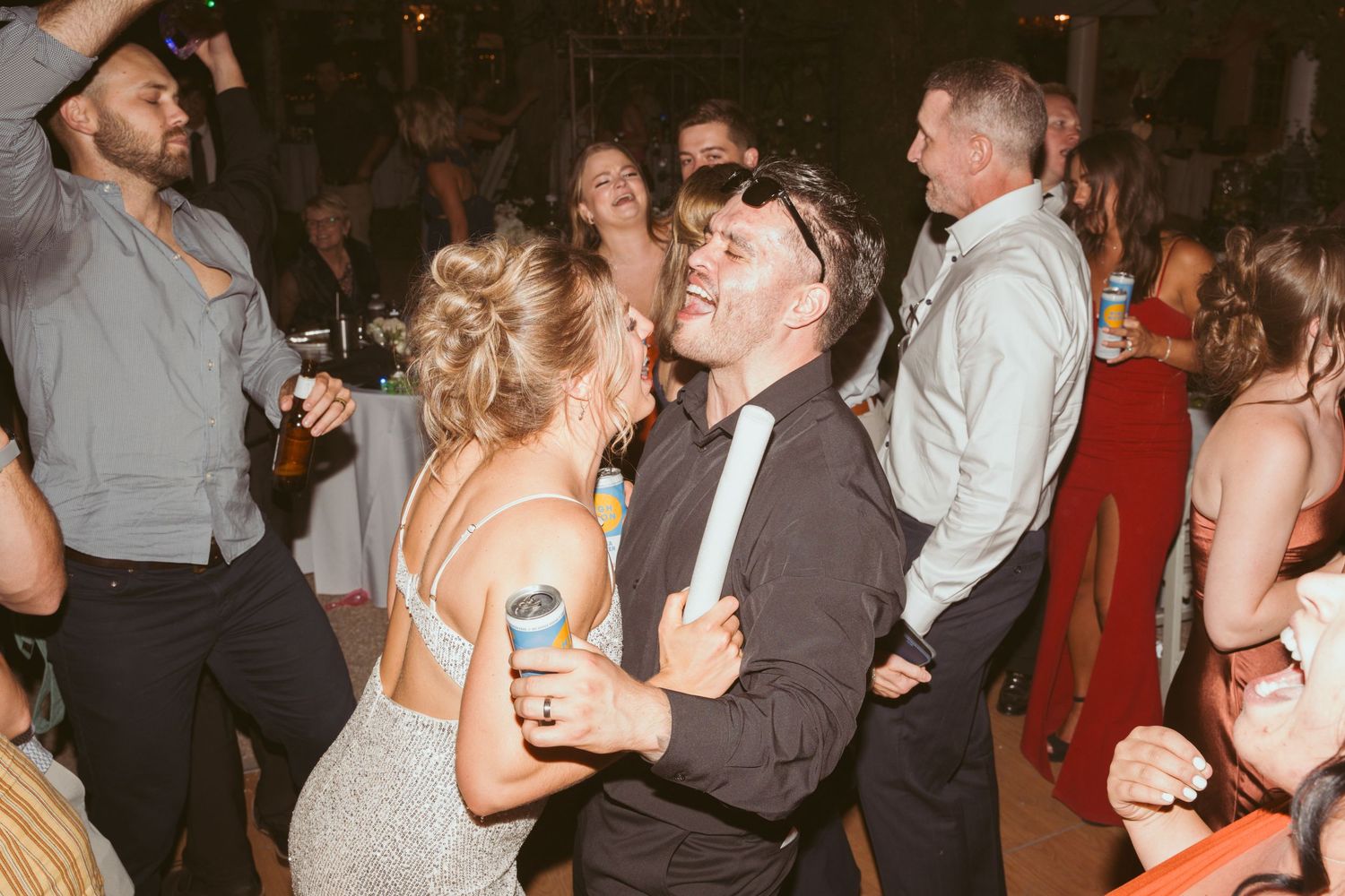 Wedding reception guests dancing and celebrating together on a lively dance floor at an evening party.