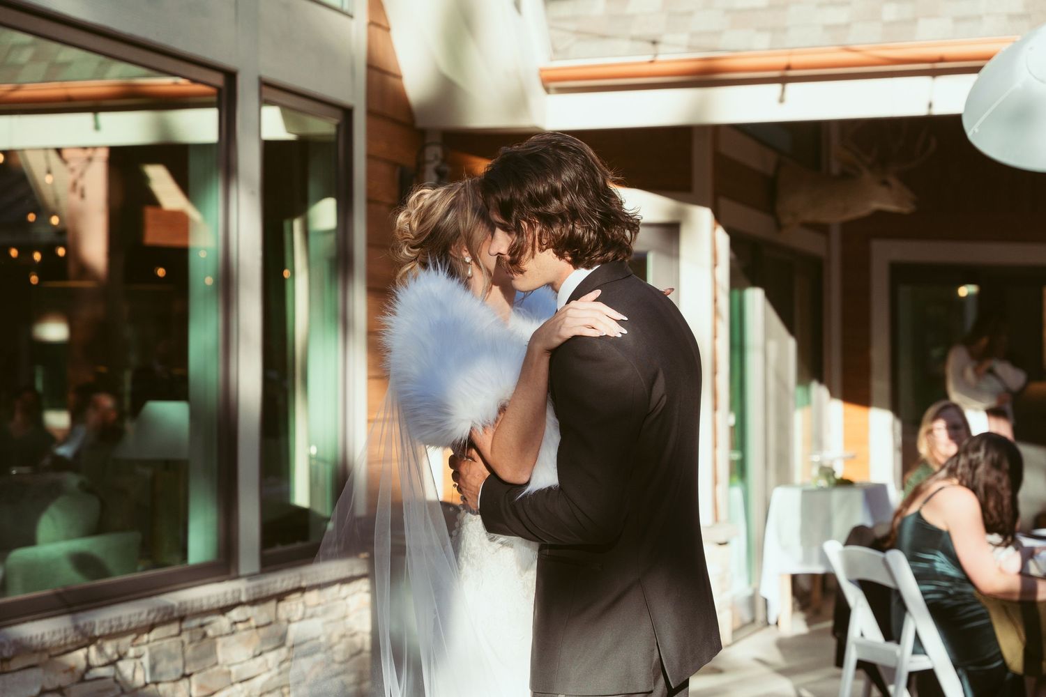 An intimate moment between newlyweds during their first dance at an outdoor venue.