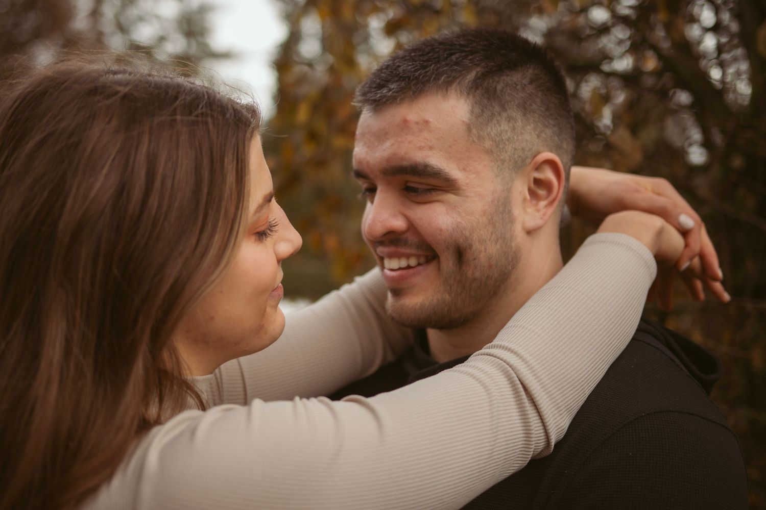 Tender moments shared between a couple in casual wear during an outdoor photoshoot.