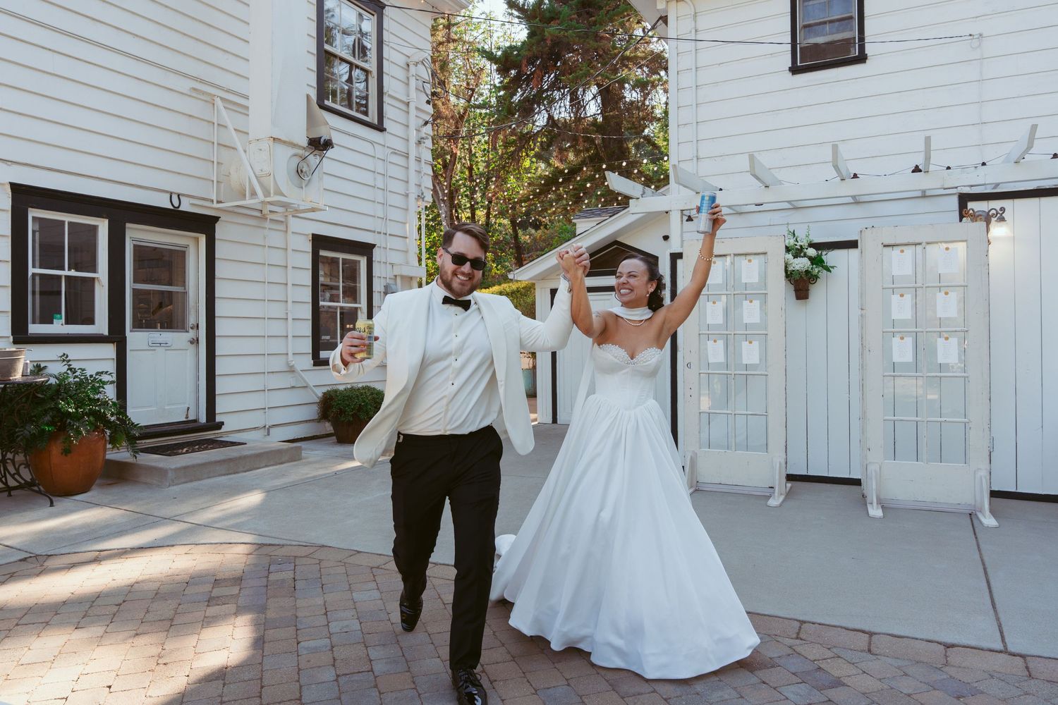 Wedding celebration sequence outside a white building with elegant architectural details.