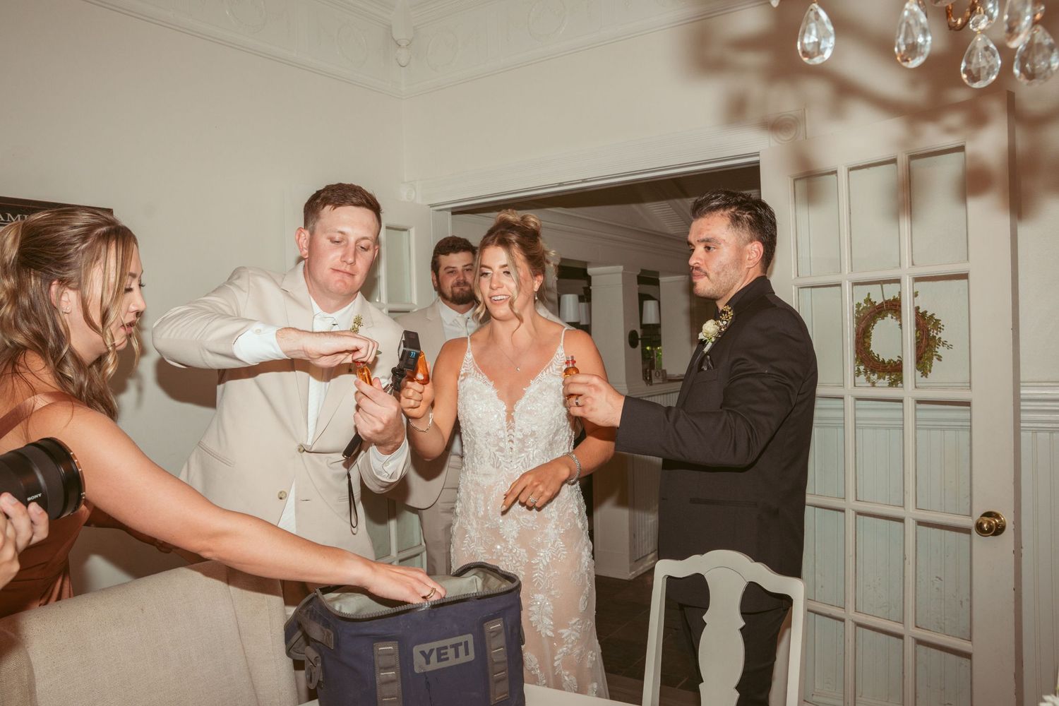 Wedding celebration indoors with guests dancing and enjoying festivities.