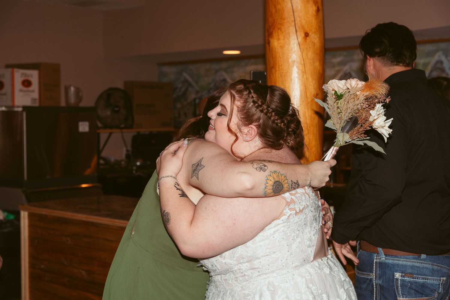 A bride and groom share their first dance together on a wooden dance floor at their wedding reception.