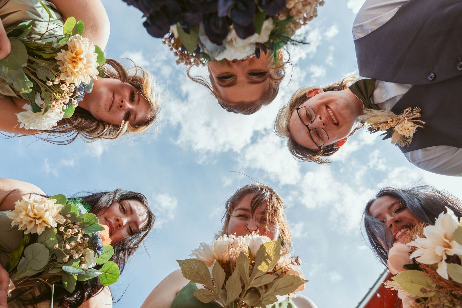 A collection of wedding party photos taken from below against a bright blue sky background.