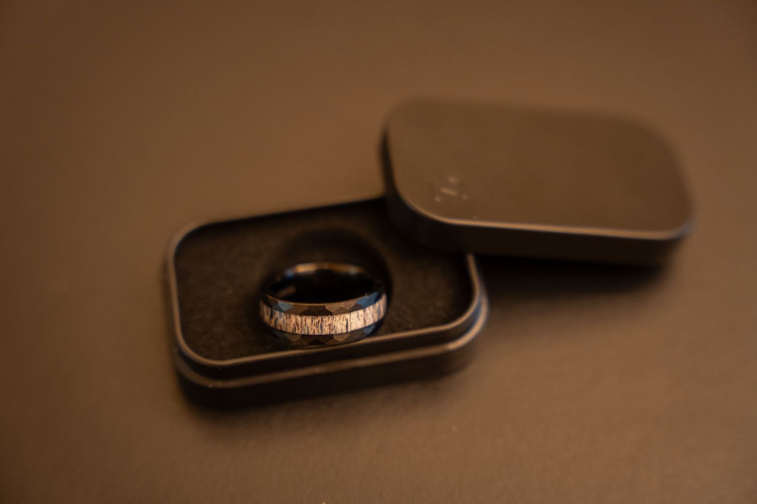Wedding rings displayed in red velvet boxes with dramatic lighting.