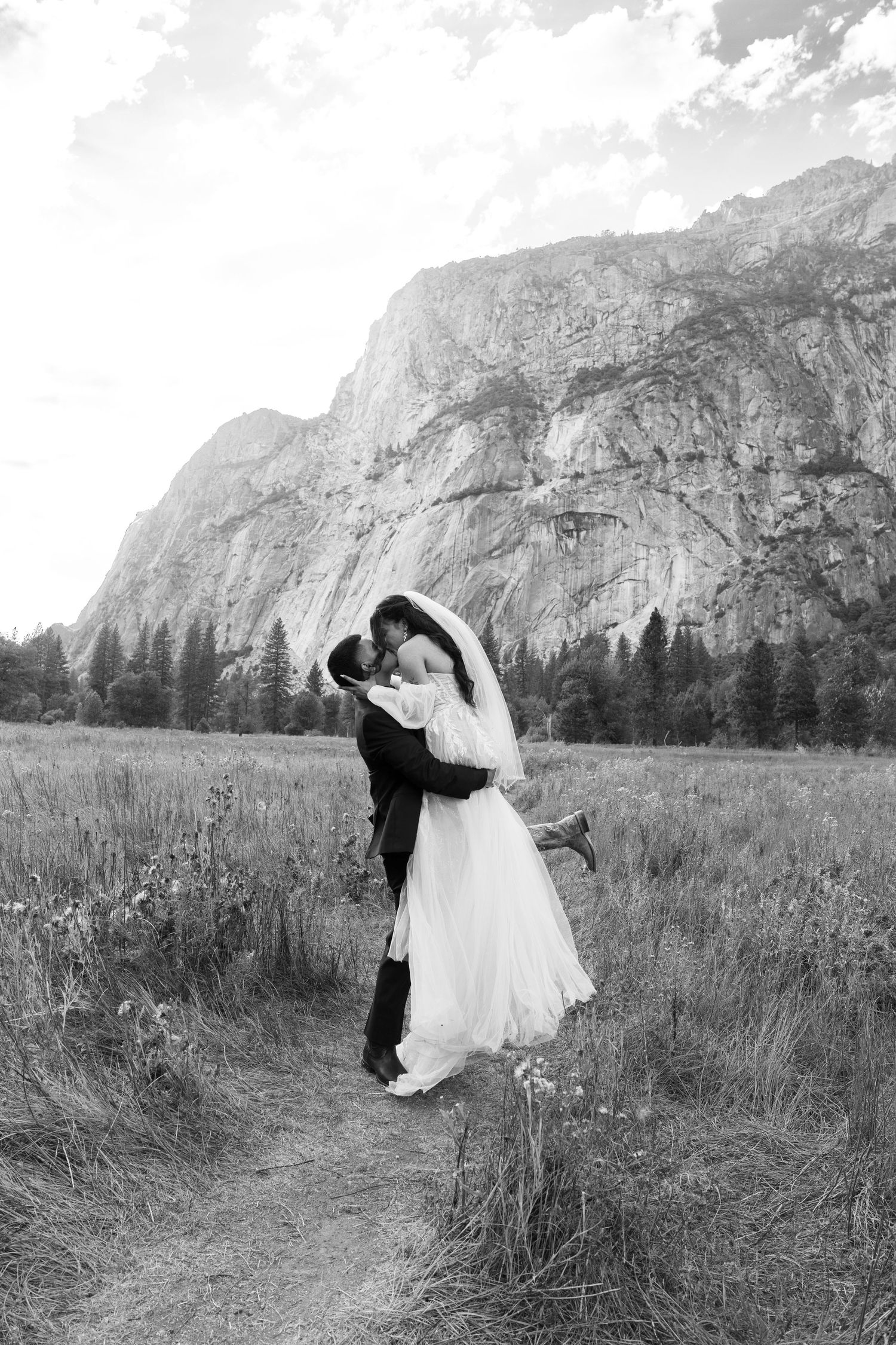 Black and white wedding portrait with dramatic mountain backdrop in Yosemite National Park.