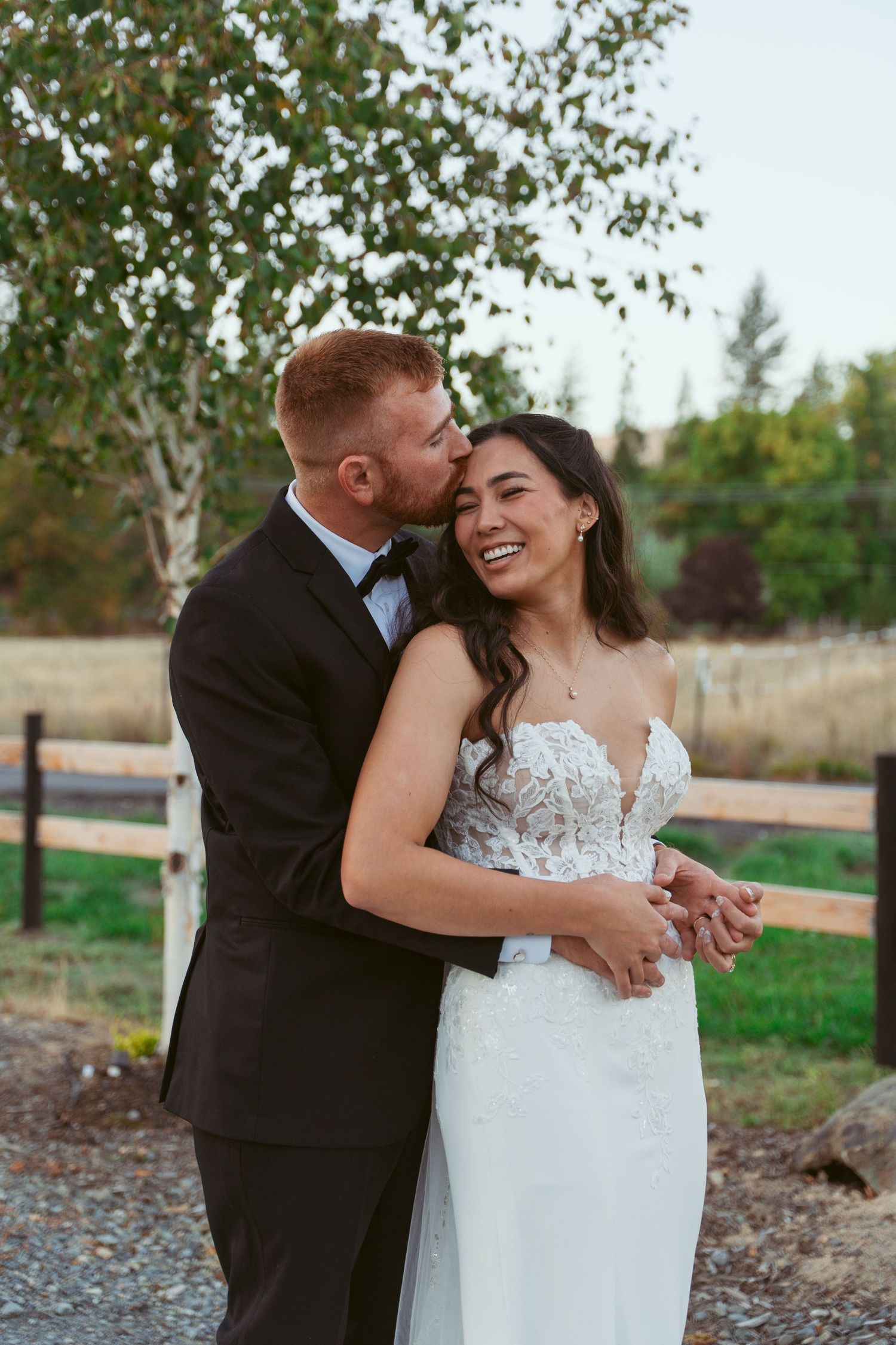 Romantic wedding couple sharing intimate moment outdoors during autumn photoshoot.