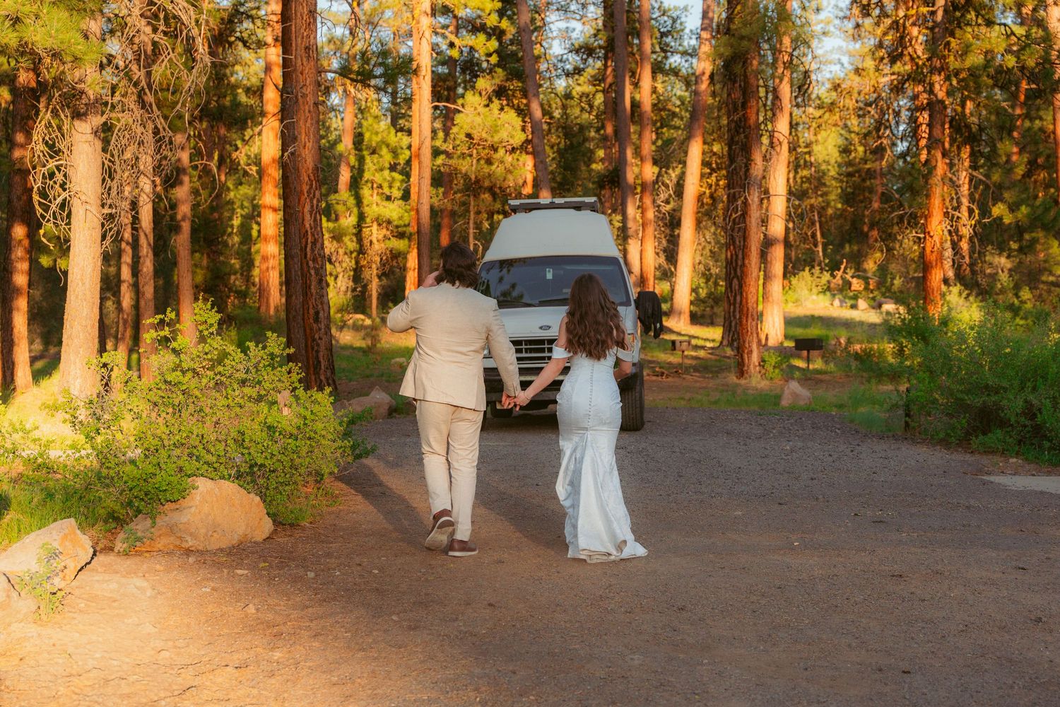 Wedding celebration in a wooded outdoor setting during golden hour.