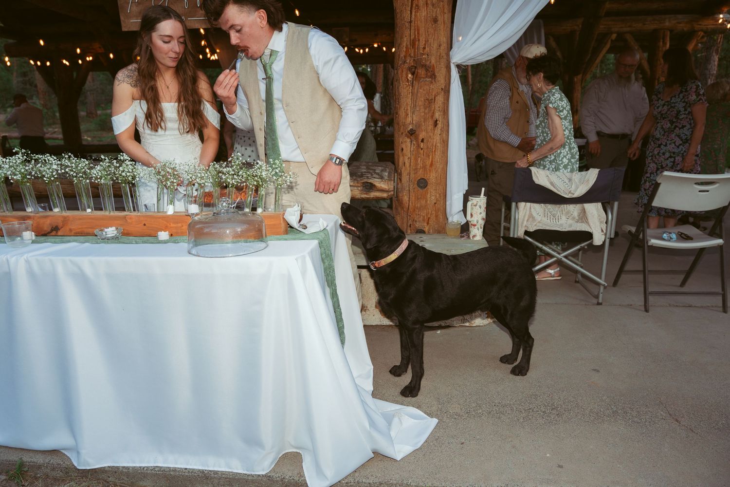 Wedding celebration in rustic barn venue with string lights and wooden architectural details.