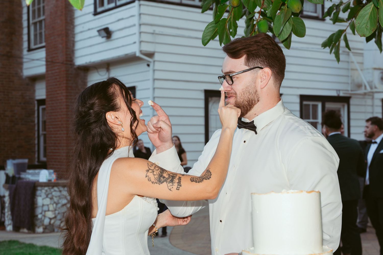 A couple shares a fun moment during their wedding cake feeding tradition.