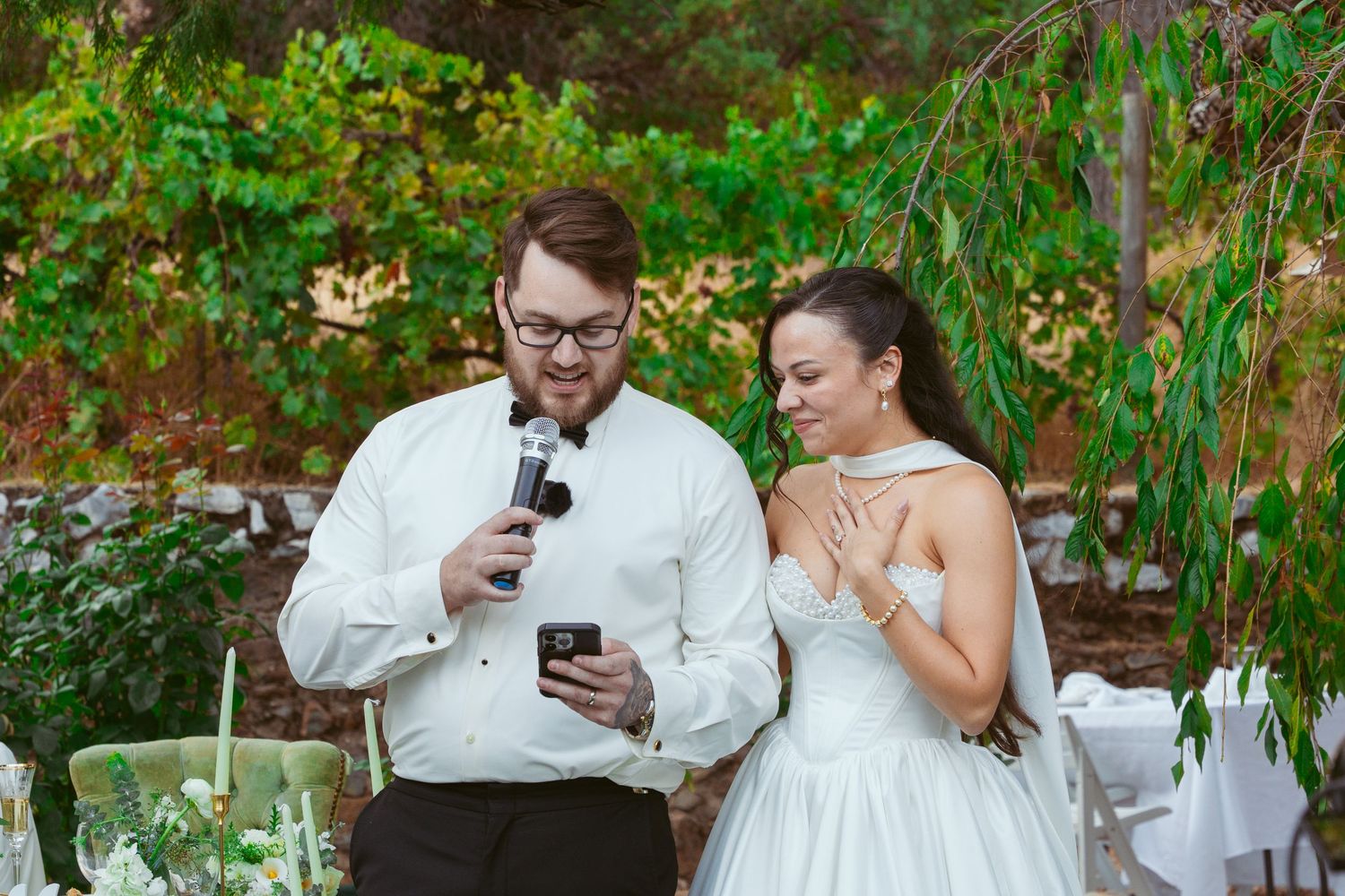 Wedding party enjoying candid moments in garden setting.