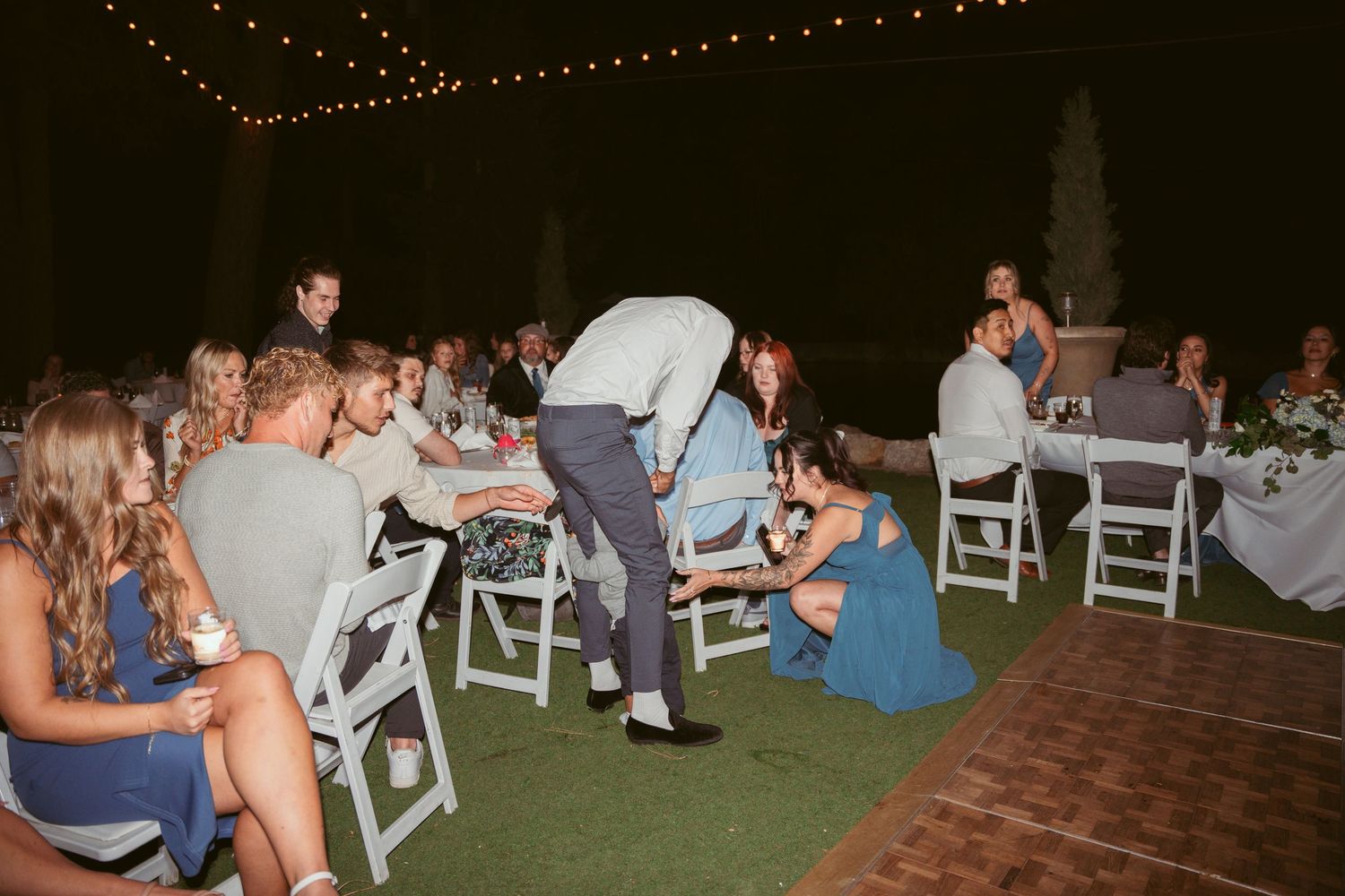 Wedding guests enjoying the dance floor at a nighttime outdoor celebration.