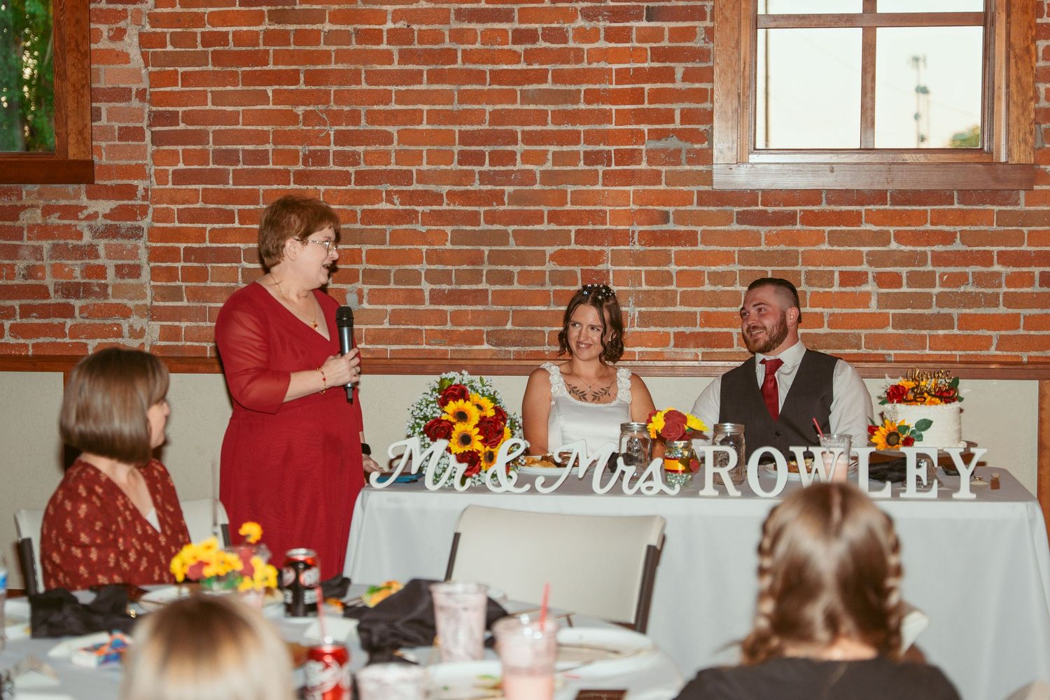 Wedding reception in industrial venue with exposed brick walls and elegant table decorations.