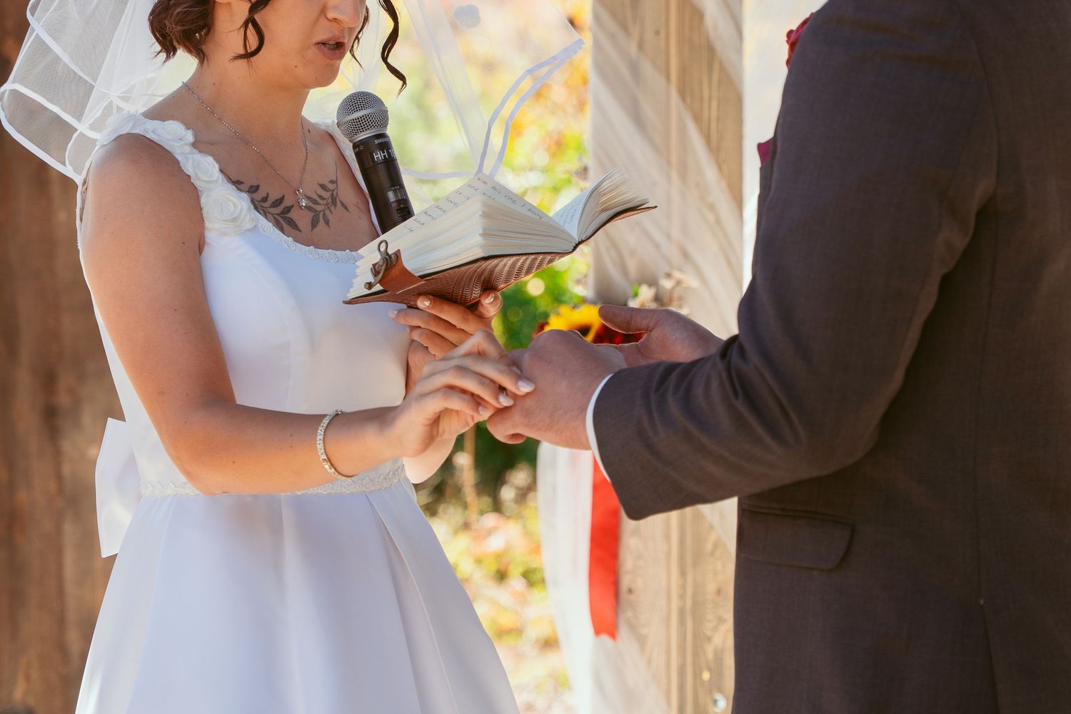 Candid wedding ceremony moments unfold beneath a rustic wooden structure.