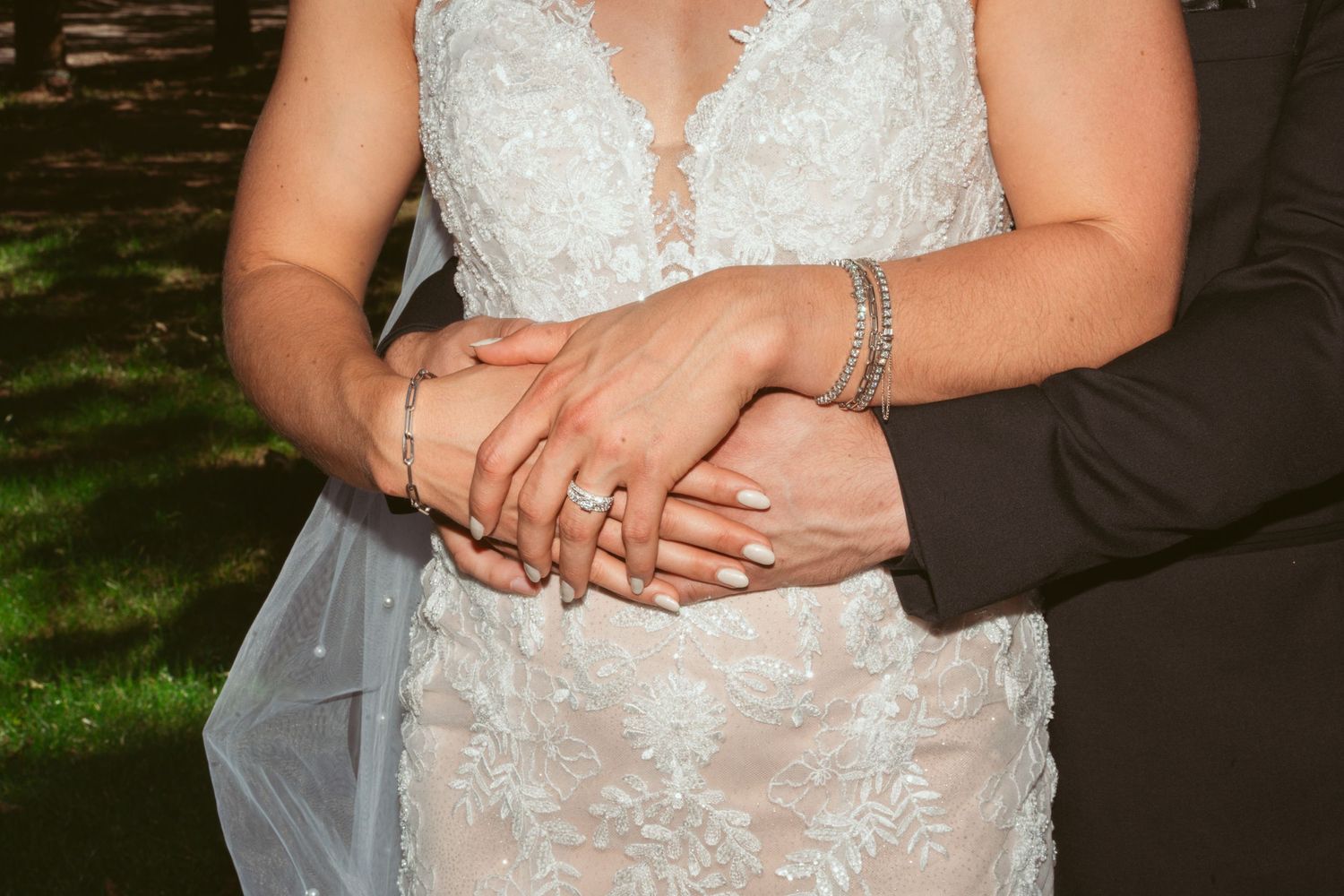 Close-up details of an elegant white lace wedding dress with intricate beading and embroidery patterns.