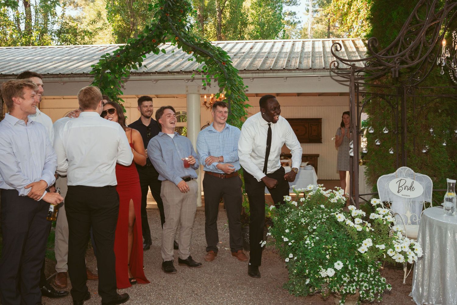 Wedding guests socialize on a decorated outdoor patio during an evening reception.