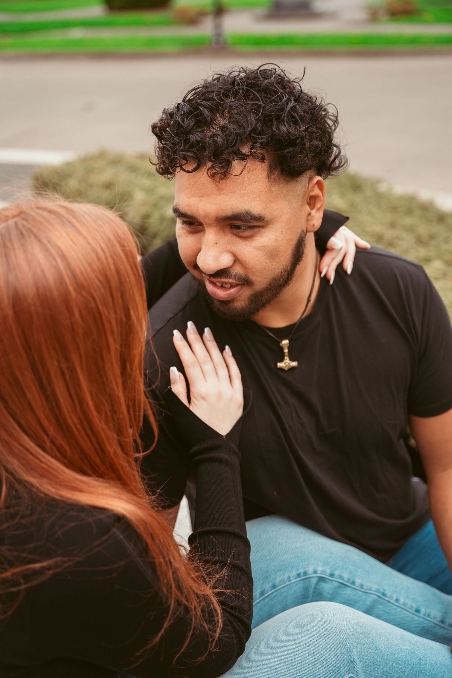 Close-up candid moment between two people sharing a laugh outdoors.