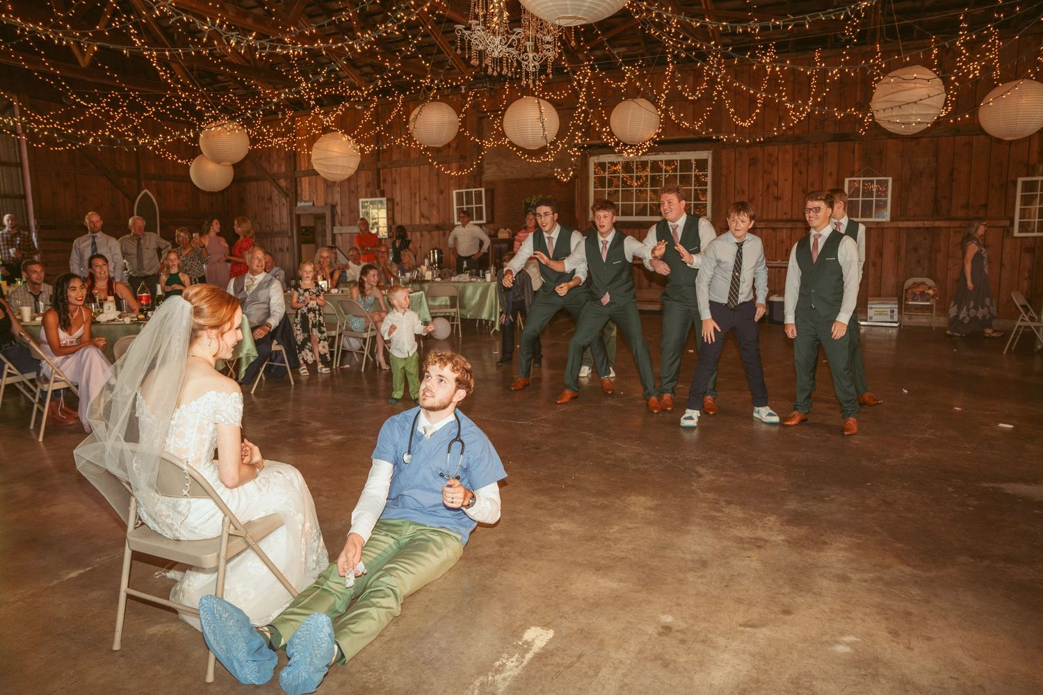 Festive dance performance during rustic barn wedding reception.