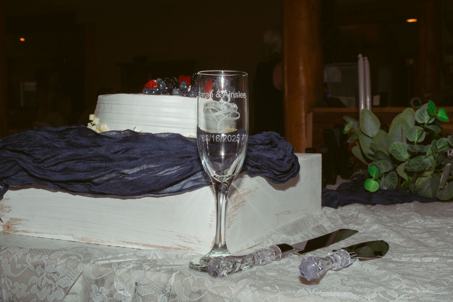 Wine glasses and decorative items arranged on a dark surface in a dimly lit setting.