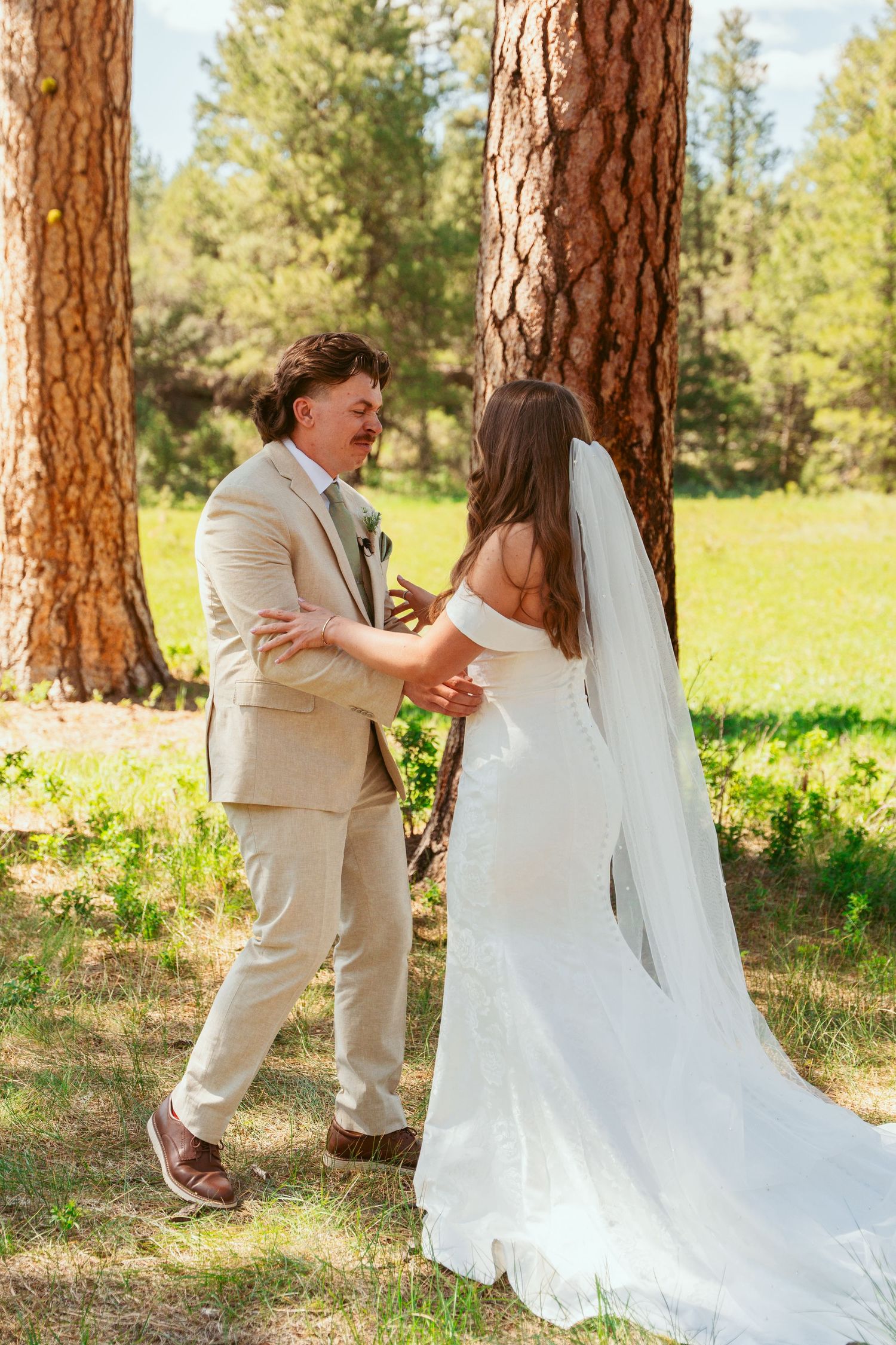 A joyful wedding first look sequence captured in golden sunlight among towering pine trees.