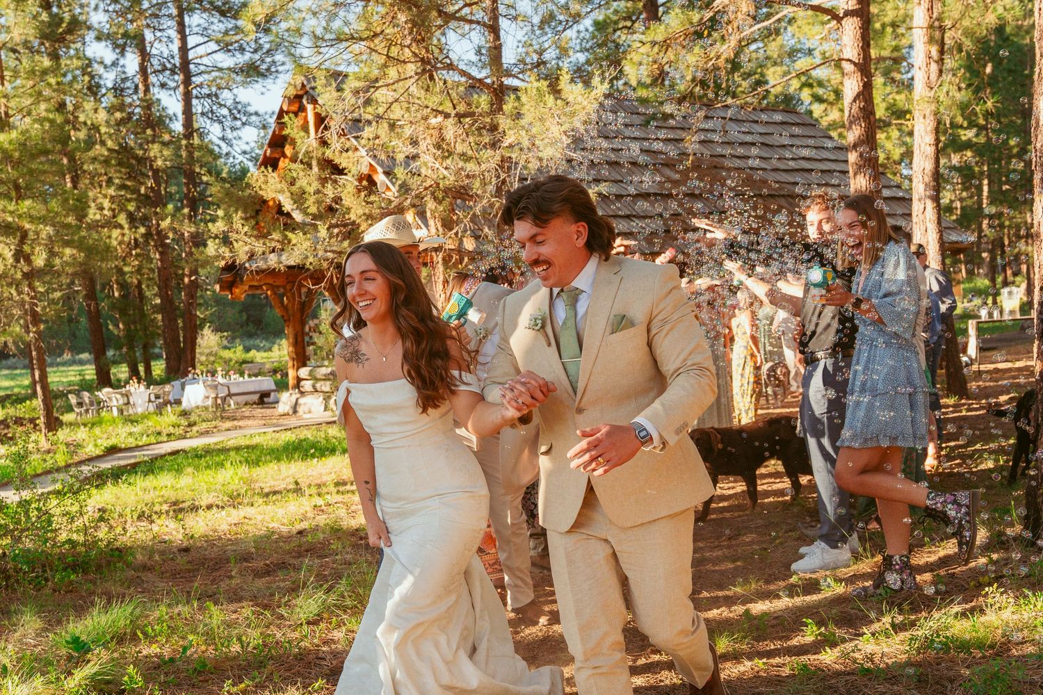 Wedding party enjoys festivities in a scenic forest location during sunset.