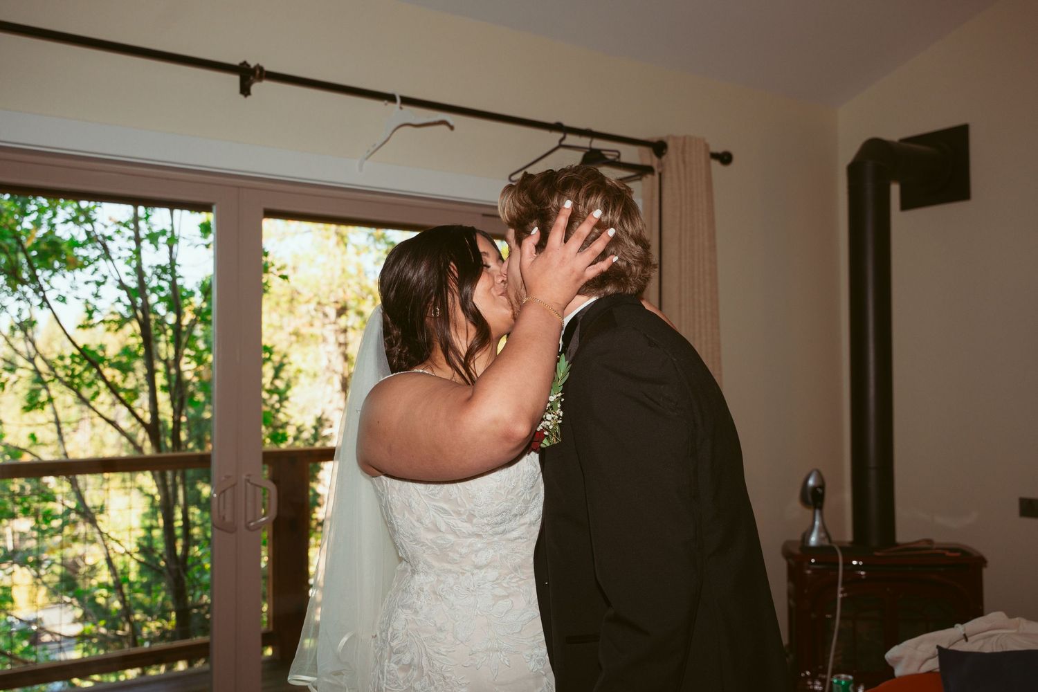 Couple shares intimate moment during indoor wedding preparation.
