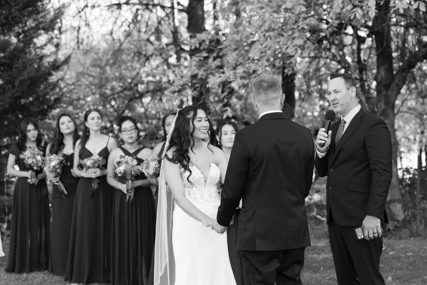 Black and white wedding party portrait with formal poses outdoors.