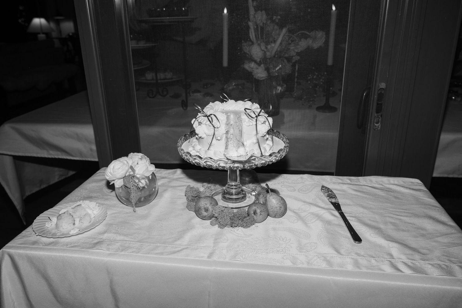 Formal dining table decorated with white tablecloths and crystal glassware for a wedding reception.
